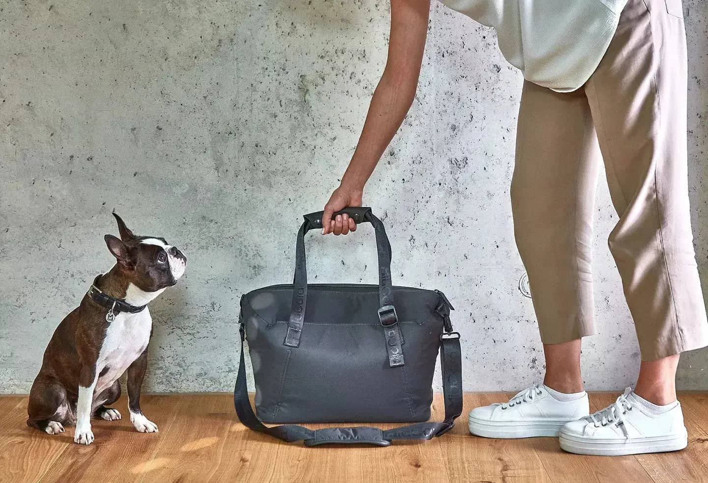 A weekender bag featuring monochrome nylon strap and matte hardware